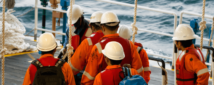Seafarers in hard hats on deck